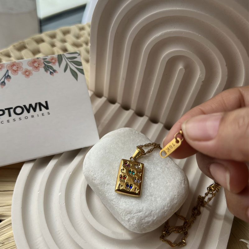 Gold rectangular pendant with floral gemstone detail on rope chain – Meadow Bloom Necklace by Uptown Accessories