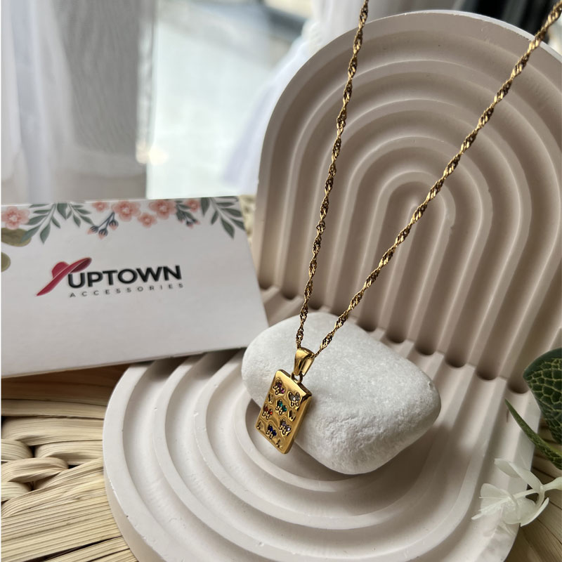 Gold rectangular pendant with floral gemstone detail on rope chain – Meadow Bloom Necklace by Uptown Accessories