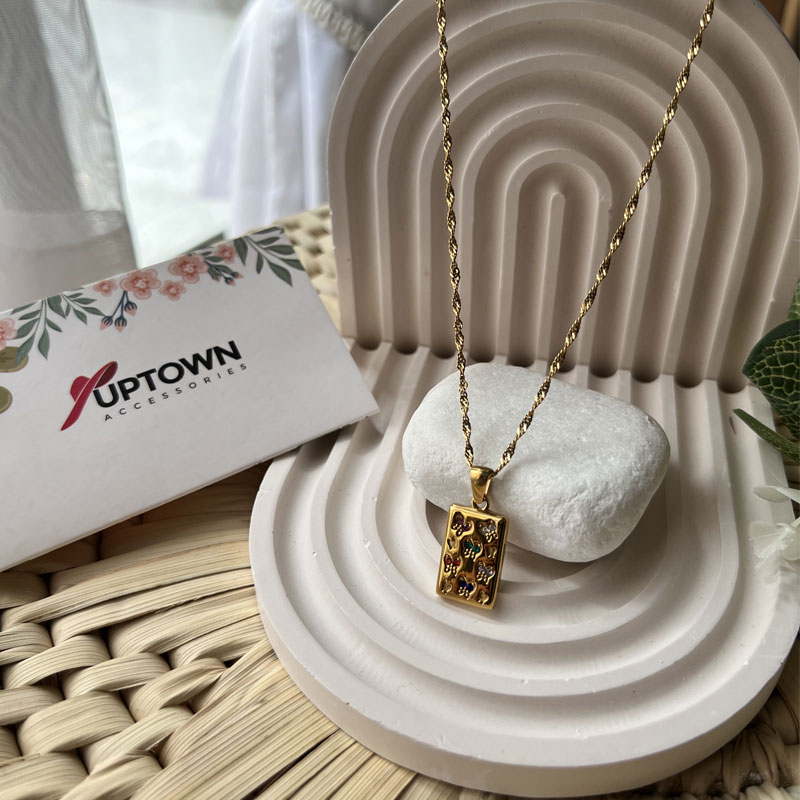 Gold rectangular pendant with floral gemstone detail on rope chain – Meadow Bloom Necklace by Uptown Accessories